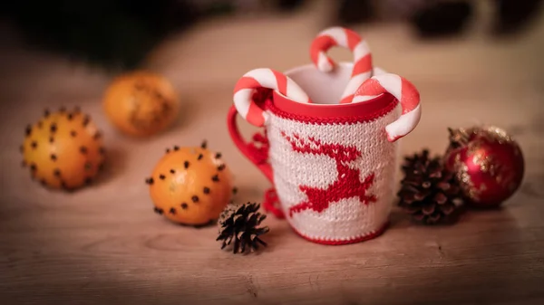 Tazza di Natale e arance su sfondo di legno sfocato. — Foto Stock