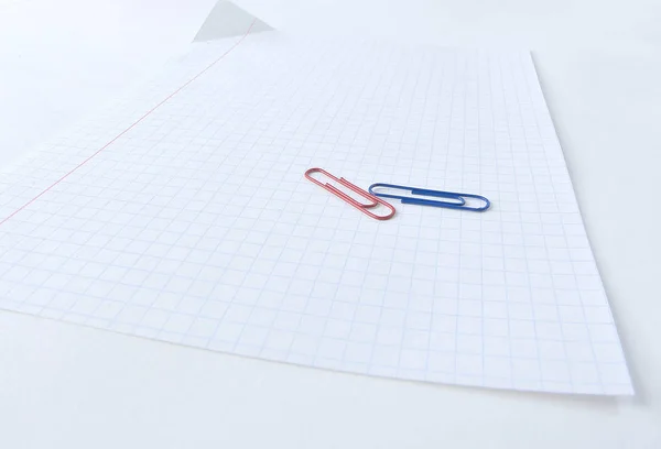 Close up.a sheet of notebook and paper clip .photo with copy spa — Stock Photo, Image