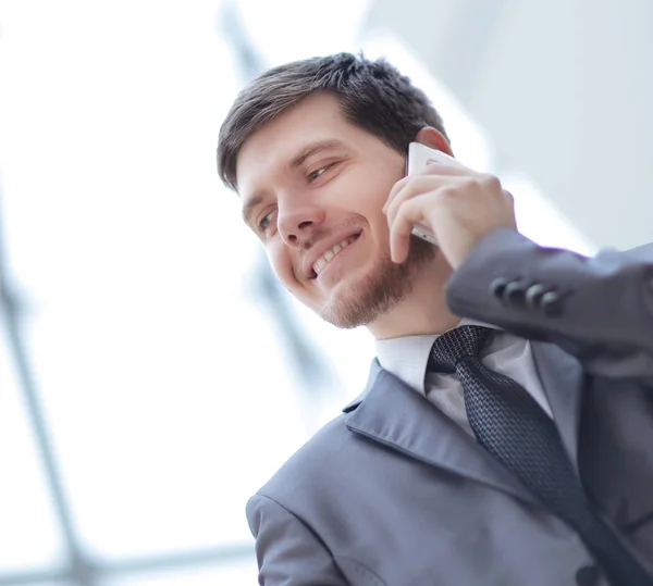 Close up. smiling businessman talking on mobile phone — стоковое фото