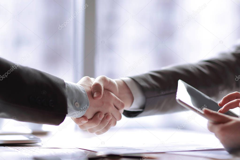 close up. the financial partners shaking hands over a Desk