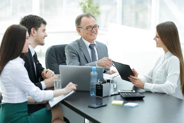 Gerente discutiendo problemas de trabajo con sus asistentes detrás de un escritorio — Foto de Stock