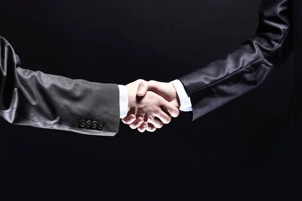 Närbild. Handshake business partners.isolated på svart backgrou — Stockfoto