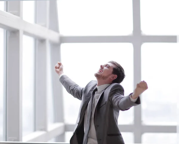 Hombre de negocios triunfante de pie en el office.photo con espacio para copias —  Fotos de Stock