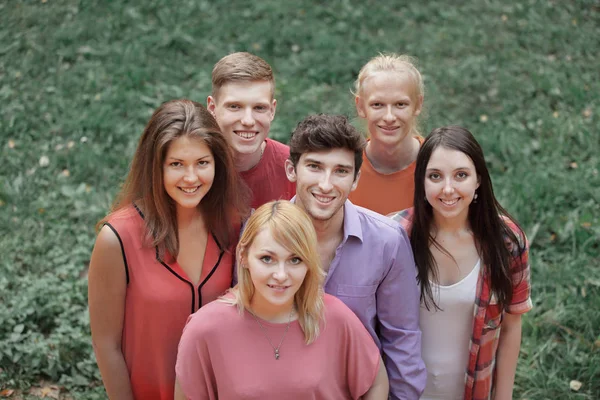 Portret utytułowanej grupy młodych ludzi na zielonym trawniku — Zdjęcie stockowe