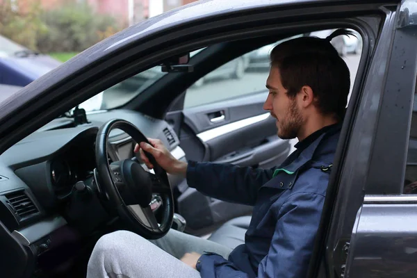 successful man behind the wheel of a car.