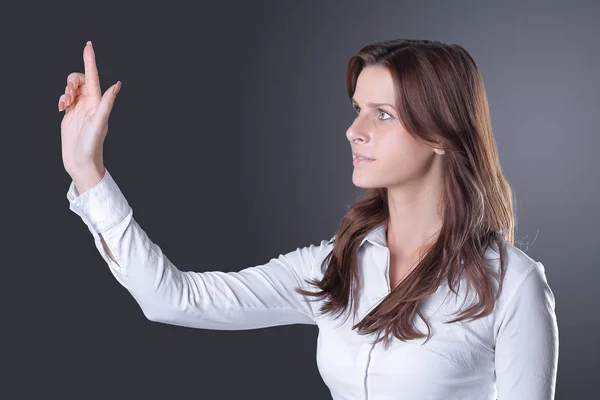 Moderna mujer de negocios de éxito presiona un botón virtual.aislado en la oscuridad — Foto de Stock