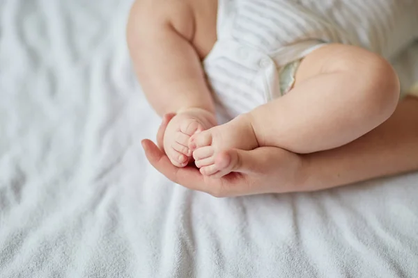 Moeders handen zorgvuldig houden van babys voet met tederheid — Stockfoto