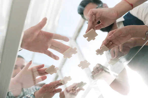 Business team with pieces of puzzle in office — Stock Photo, Image