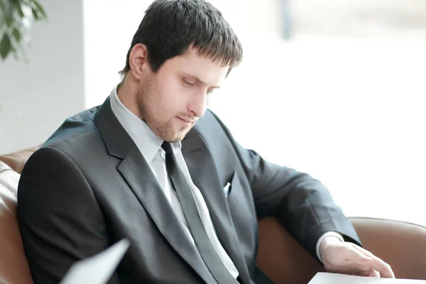 Close up. smiling businessman reading a business document — Stock Photo, Image