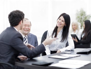 Proje Yöneticisi ve personeli masada konuşuyor.