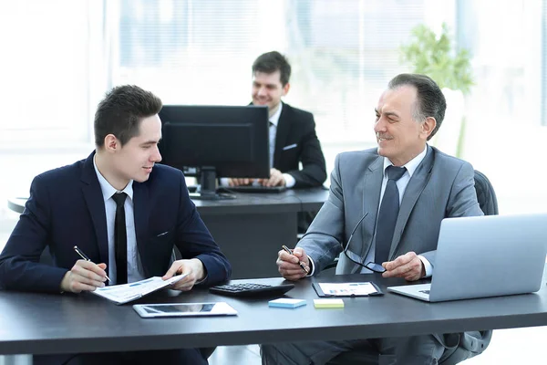 Zakelijke collega 's zitten aan een bureau in het kantoor. — Stockfoto