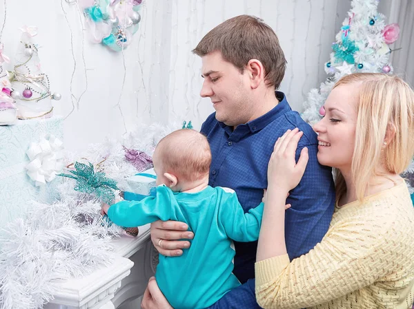 Padres cariñosos muestran a su bebé regalos de Navidad — Foto de Stock