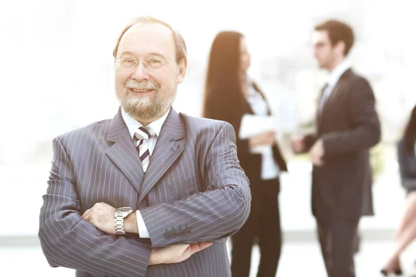 Hombre de negocios en la oficina con un grupo detrás de él — Foto de Stock