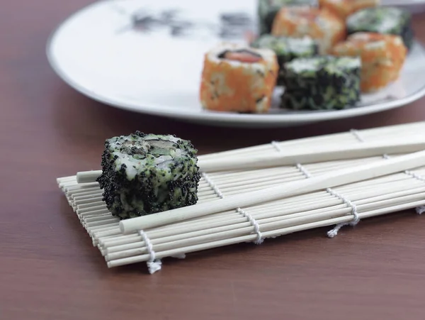 Suşi rulo ve chopsticks ahşap bir masa üzerinde — Stok fotoğraf