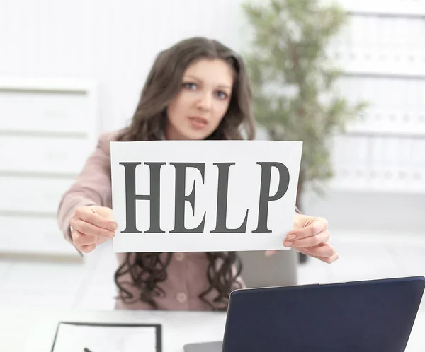 Молода бізнес-леді показує плакат, який каже допомогу . — стокове фото