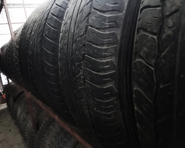 Row of worn tires on a rack in the garage — Stock Photo, Image