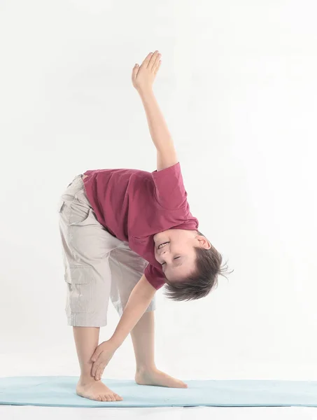 Маленький мальчик выполняет упражнение, чтобы растянуть muscles.isolated на белом — стоковое фото