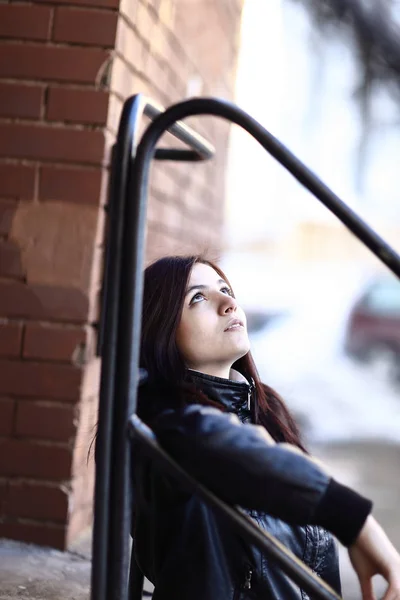 Pretty young woman standing next to a city building — стоковое фото