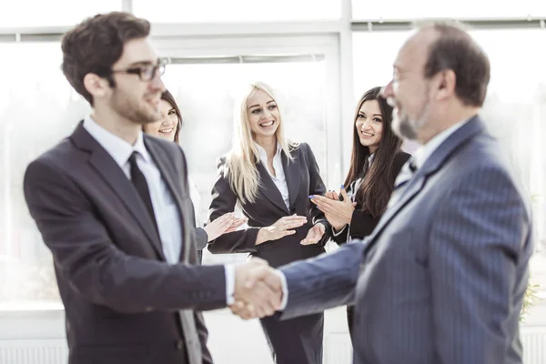 Bienvenida y apretón de manos de los socios comerciales en el contexto de aplaudir a los empleados — Foto de Stock