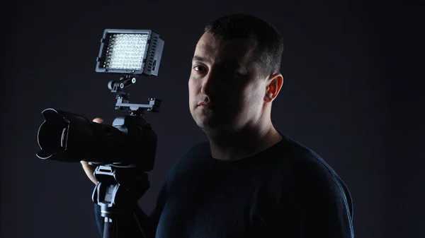 Fotógrafo profissional com uma camera.isolated em fundo preto — Fotografia de Stock