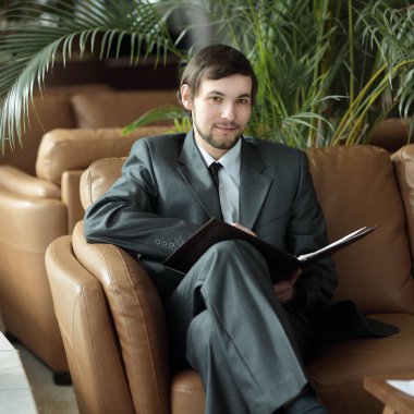 up.smiling yakışıklı işadamı belgeleri otelin lobisinde okuma kapatın