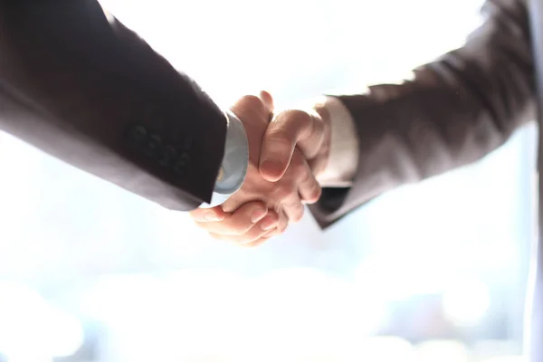 Close up. handshake business partners on the background of the office window — Stock Photo, Image