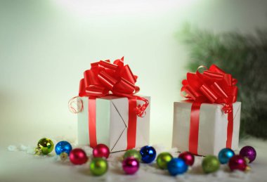 Noel arkaplanda kırmızı kurdeleli iki beyaz kutu..