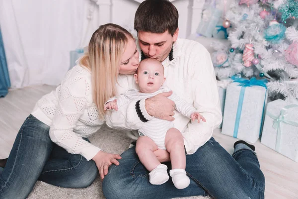 Padres felices besan a su bebé en la víspera de Navidad — Foto de Stock