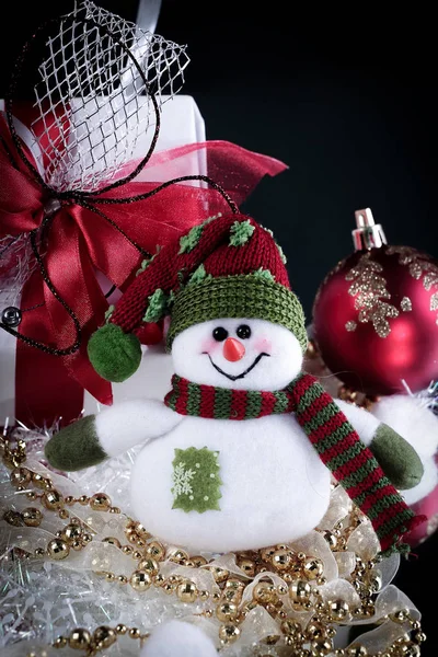 Lindo muñeco de nieve caja de juguete con regalos sobre un fondo negro . —  Fotos de Stock