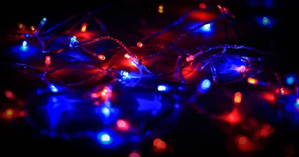 Fundo festivo.luzes coloridas borradas em um fundo preto — Fotografia de Stock