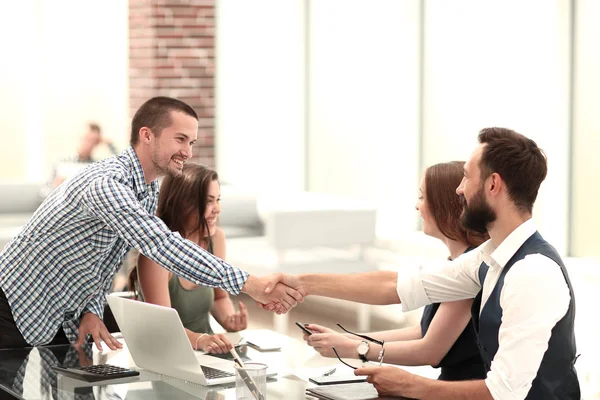 Smiling business partners shaking hands over the Desk. — Stock Photo, Image