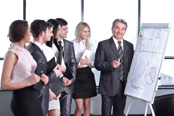 Group of business people looking at the graph on flipchart — Stock Photo, Image