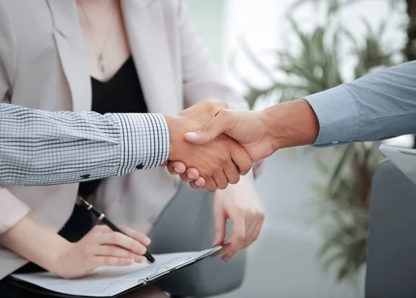 Closeup.Handshake finansiella partner på bakgrunden av kontoret — Stockfoto