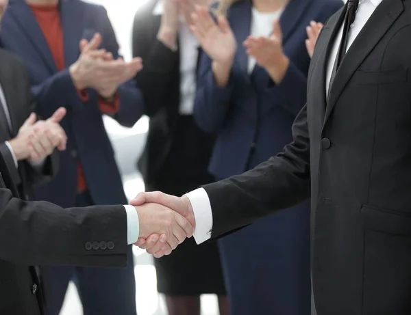 Vicino. stretta di mano di partner commerciali sullo sfondo di applaudire business team — Foto Stock