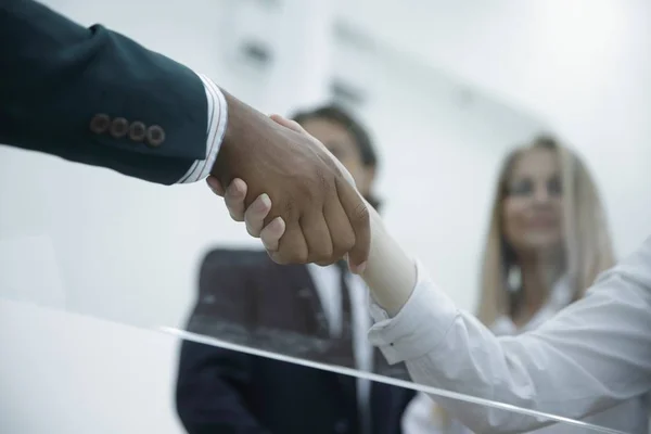 Bottom view .handshake mulheres de negócios com um parceiro de negócios — Fotografia de Stock