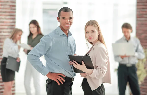 Pareja de negocios de pie en una oficina moderna — Foto de Stock