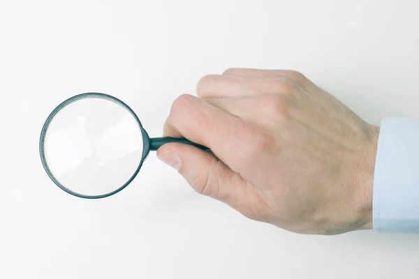 Closeup.magnifier in the hand of businessman. isolated on a white background. — Stock Photo, Image