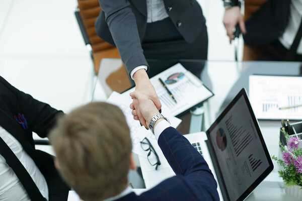 Закрывай. рукопожатие торговых партнеров за столом переговоров
