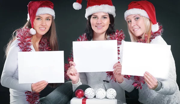 Três meninas felizes vestidas como Papai Noel sentado com um bu — Fotografia de Stock