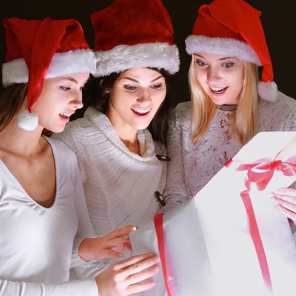 Grupo de estudantes do sexo feminino em trajes de Papai Noel abrindo um bo — Fotografia de Stock