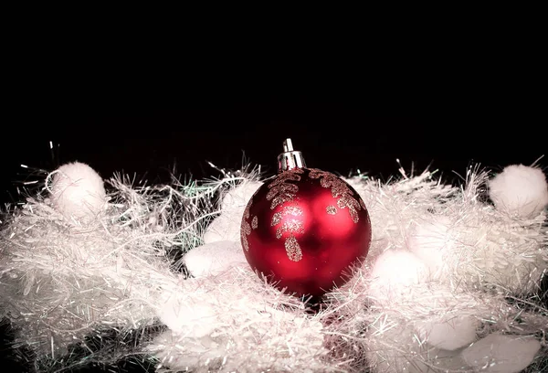 Bela bola de Natal vermelho em um fundo preto. — Fotografia de Stock