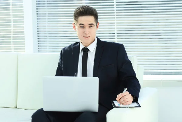 Hombre de negocios confiado que trabaja en el ordenador portátil sentado en el amplio — Foto de Stock