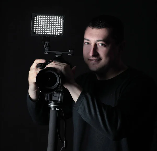 Photographe professionnel avec appareil photo sur trépied. Isolé sur fond noir — Photo
