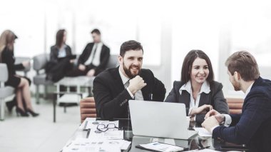 şirket çalışanlarının iş üstünde laptop ile şirketin gelişimi hakkında bilgi