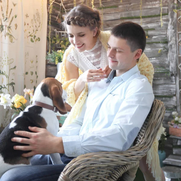 Junges Paar mit Haustier sitzt auf einem Stuhl — Stockfoto