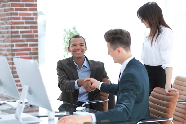 Handschlag-Geschäftsleute hinter einem Schreibtisch im Büro — Stockfoto