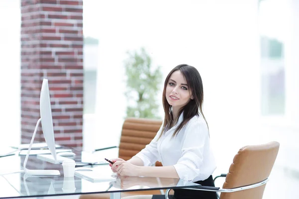 Självsäker affärskvinna som sitter bakom ett skrivbord — Stockfoto