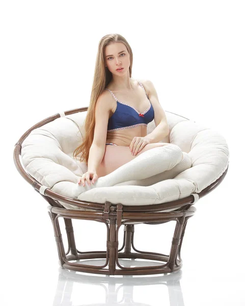 Mladá sexy žena sedí v komfortní chair.isolated na bílém — Stock fotografie