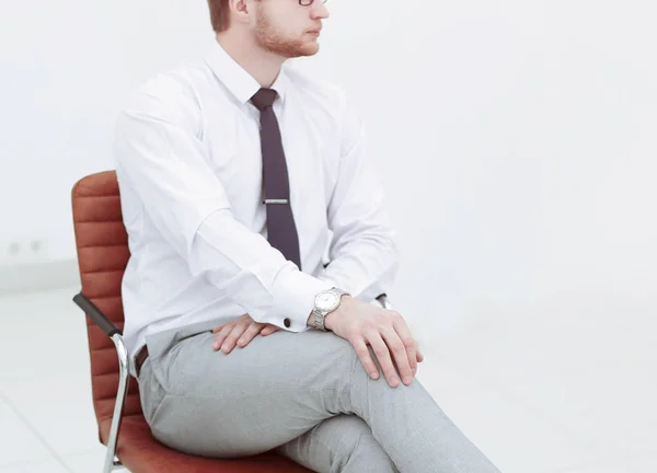 Ernsthafter junger Geschäftsmann sitzt im Bürostuhl. — Stockfoto