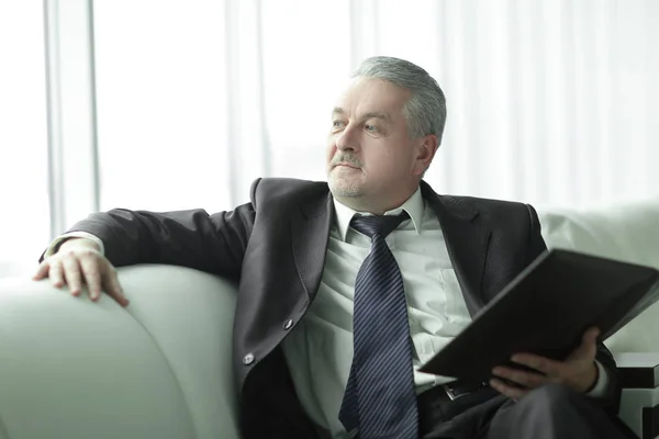 Boss with clipboard sitting on the office couch.business concept — Stock Photo, Image